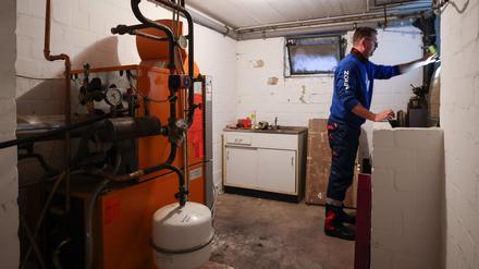 Ein Mitarbeiter eines Diesel- und Heizöl-Unternehmens prüft die beiden Kunststofftanks einer Heizung in einem Heizungskeller bei der Heizöllieferung für ein Einfamilienhaus (Symbolbild).