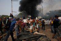 Menschen bergen Hilfsgüter aus dem brennenden Lastwagen