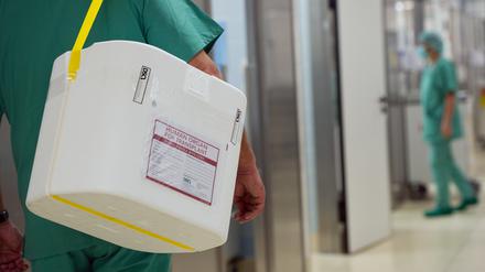 Ein Styropor-Behälter zum Transport von zur Transplantation vorgesehenen Organen wird an einem OP-Saal vorbeigetragen. 