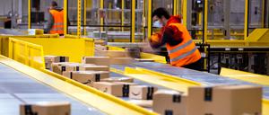 Mitarbeiter sortieren Paketsendungen des Online-Händlers Amazon in einem Verteilzentrum. 