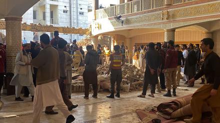 Sicherheitspersonal untersucht die Moschee, nachdem sich dort ein mutmaßlicher Selbstmordattentäter in die Luft gesprengt hatte.