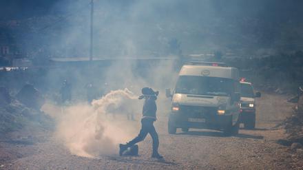 Ein palästinensischer Demonstrant wirft einen Stein auf israelische Sicherheitskräfte während einer Demonstration in Nablus am 24. Februar 2023. 