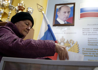 Ein Wahllokal in einer Schule in Moskau, im Hintergrund ein Bild von Russlands Präsident Wladimir Putin.