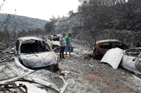 Anwohner begutachten ausgebrannte Fahrzeuge im Ort Damour südlich von Beirut. Ein Waldbrand war durch den Ort gezogen.