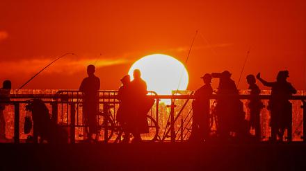 People stand on a pier during sunset in the Baltic Sea resort of Zelenogradsk in the Kaliningrad region, Russia June 23, 2022. Picture taken June 23, 2022. REUTERS/Vitaly Nevar