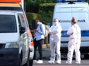 Kriminaltechniker und Gerichtsmediziner in weißen Schutzanzügen ermitteln am Tatort in Spandau.