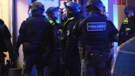 Polizisten stehen vor einem Münzgeschäft in Berlin-Friedrichshain, in dem am Montagnachmittag der Alarm ausgelöst worden war. Es bestehe der Verdacht eines Raubüberfalls.