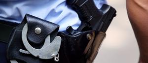 Ein Polizist mit Handschellen und Pistole am Gürtel. 