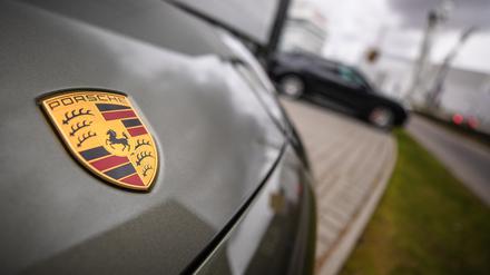 Das Porsche-Logo ist am Firmensitz in Stuttgart-Zuffenhausen auf einem Auto zu sehen.