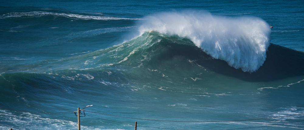 Zahlreiche Menschen beobachten die ersten großen Wellen der Wintersaison am berühmten Surfer-Strand Praia do Norte oder Nordstrand (Archivfoto).