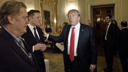 Trump-Berater Steve Bannon (l.) sieht zu, wie US-Präsident Donald Trump Elon Musk, CEO von SpaceX und Tesla, vor einem Politik- und Strategieforum mit Führungskräften im State Dining Room des Weißen Hauses am 3. Februar 2017 in Washington, D.C. begrüßt. 