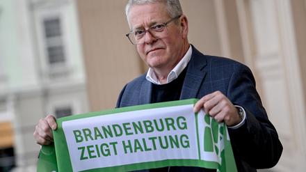 Jens Warnken, Präsident der IHK Cottbus, zeigt am Rande der Pressekonferenz zum Aufruf „Brandenburg zeigt Haltung! Für Demokratie und Zusammenhalt!“ ein Banner.