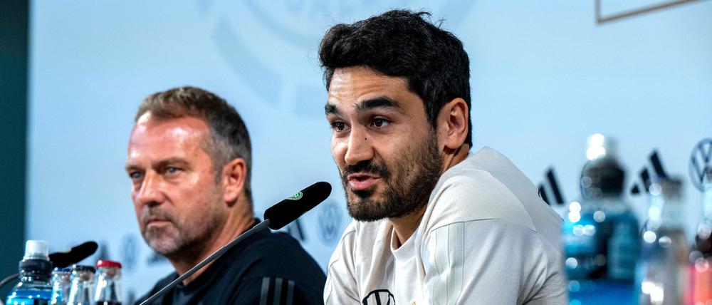 Nationalspieler Ilkay Gündogan (r) und Bundestrainer Hansi Flick sprechen bei der Pressekonferenz.