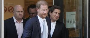 Prinz Harry (M) und sein Anwalt David Sherborne (r) verlassen den High Court nach ihrer Zeugenaussage.