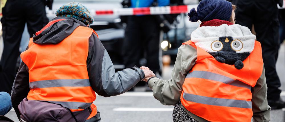 dpatopbilder - 05.12.2022, Bayern, München: Aktivisten der Klimaschutz-Initiative ·Letzte Generation· haben sich am Stachus mit ihren Händen auf die Straße geklebt. Foto: Matthias Balk/dpa +++ dpa-Bildfunk +++