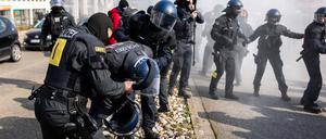 Ein von einem Pulverlöscher getroffener Polizist wird während einer Demonstration gegen den Landesparteitag der AfD Baden-Württemberg von zwei weiteren Polizisten versorgt. 