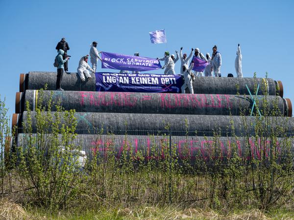 Aus Protest gegen Terminals für Flüssigerdgas (LNG) klettern Aktivisten auf Rügen auf Pipeline-Röhren, die für den Bau einer solchen Anlage gedacht sind.