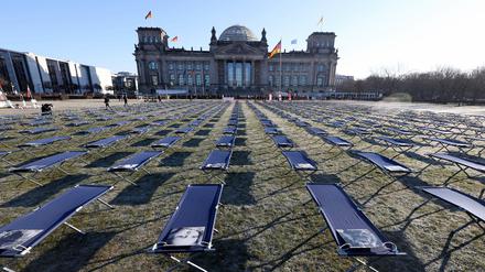 Bei einer Demonstration von Long Covid und ME/CFS-Betroffenen sind vor dem Reichstagsgebäude 400 Feldbetten mit Porträts von Betroffenen aus ganz Deutschland aufgestellt worden. 