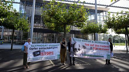 14.09.2023, Nordrhein-Westfalen, Leverkusen: Nicht alle sind für eine Verlängerung der Zulassung: vier Personen halten vor der Konzernzentrale von Baye Banner in den Händen. Die Aktion richtet sich gegen die Verlängerung der EU-Zulassung des Pestizids Glyphosat. 