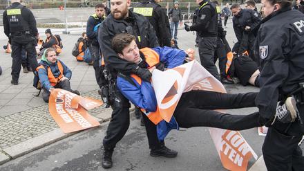 Ein Teilnehmer eines unangemeldeten Protests auf der Straße des 17. Juni in der Nähe des Brandenburger Tors wird von Polizisten weggetragen. 
