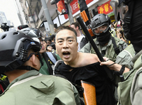 Ein Demonstrant wird von Polizisten festgehalten. 