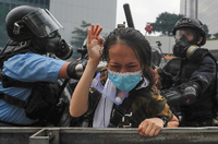 Ein Demonstrant mit einer Gasmaske wirft bei einer Straßenblockade einen Tränengasbehälter, der von der Polizei bei erneuten Unruhen eingesetzt wurde.