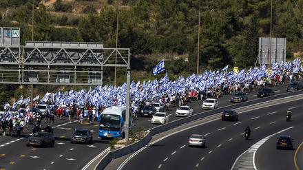 Tausende israelische Demonstranten marschieren entlang einer Autobahn, um gegen die geplante Justizreform der Regierung des israelischen Ministerpräsidenten Netanjahu zu protestieren. 