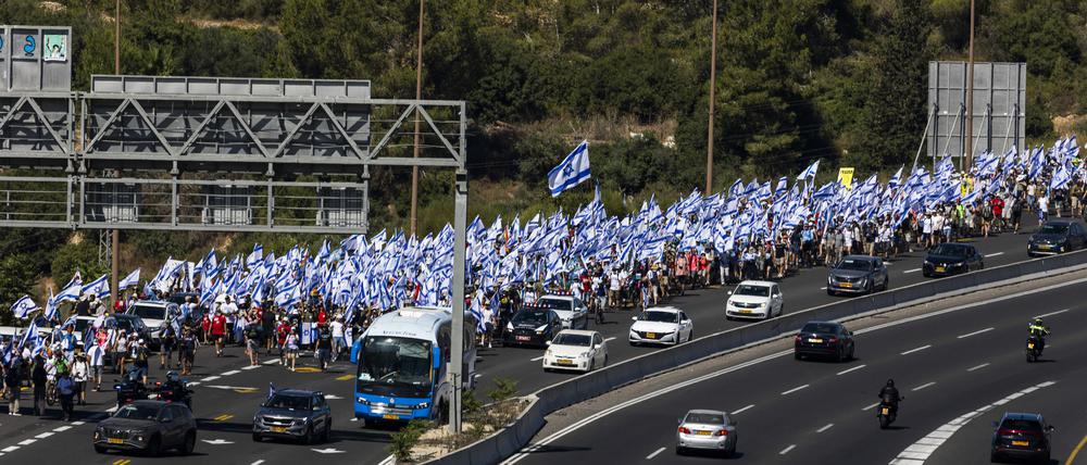 Tausende israelische Demonstranten marschieren entlang einer Autobahn, um gegen die geplante Justizreform der Regierung des israelischen Ministerpräsidenten Netanjahu zu protestieren. 