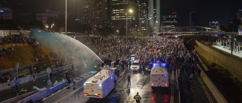 Die Bereitschaftspolizei versucht in Tel Aviv, Israel, Demonstranten während einer Demonstration gegen die Justizreform mit einem Wasserwerfer zu vertreiben. 