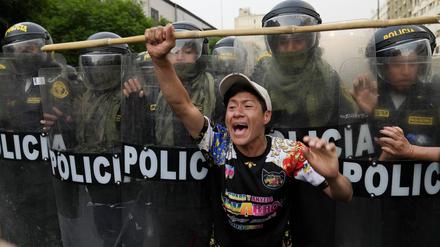 Ein regierungskritischer Demonstrant protestiert in Lima vor einer Reihe von Polizisten. 