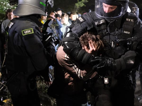Polizisten nehmen einen Demonstrierenden in Gewahrsam.