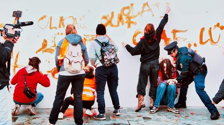 Aktivisten der Gruppe Letzte Generation werden vor dem Kanzleramt von Polizeibeamten gestoppt. Zuvor hatten sie eine Wand des Kanzleramtes mit dem Spruch „Olaf lügt“ bemalt.