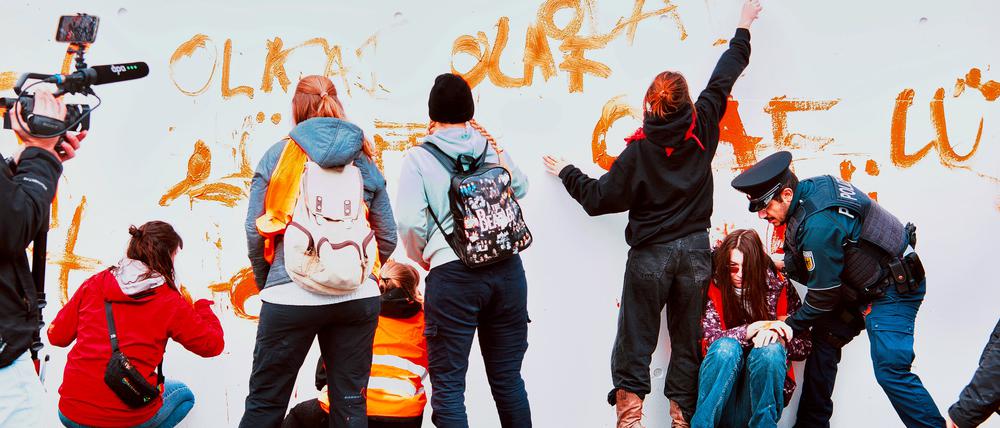 Aktivisten der Gruppe Letzte Generation werden vor dem Kanzleramt von Polizeibeamten gestoppt. Zuvor hatten sie eine Wand des Kanzleramtes mit dem Spruch „Olaf lügt“ bemalt.