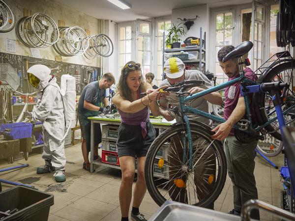 Gemeinsam reparieren Freiwillige von überall her gespendete Räder in der Werkstatt des Vereins Rückenwind. Mehr als 200 Menschen warten gerade darauf, eines zu bekommen.