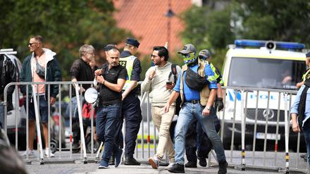 Salwan Momika, der eine Koranausgabe und die irakische Flagge verbrennen wollte, wird am 20. Juli in Stockholm von Polizisten abgeführt.