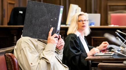 Ein angeklagter mutmaßlicher «Reichsbürger» sitzt im Hanseatischen Oberlandesgericht neben seiner Rechtsanwältin Ina Franck-Holst im Saal.