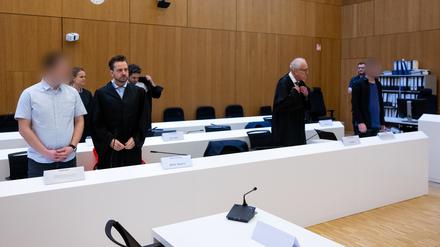 Die zwei wegen Mordes angeklagten Männer (l. und r.) stehen vor Beginn der Verhandlung im Hochsicherheitsgerichtssaal vom Landgericht München II neben ihren Rechtsanwälten Sarah Stolle (2.v.l.), Alexander Stevens (3.v.l.), Alexander Betz (4.v.l.) und Gerhard Bink (5.v.l.). 