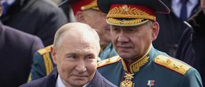 Wladimir Putin (l), Präsident von Russland, und Sergej Schoigu, Verteidigungsminister von Russland, verlassen den Roten Platz.