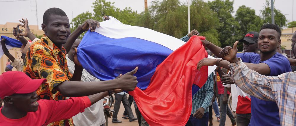 Anhänger meuternder Soldaten nehmen an einer Demonstration teil während sie eine russische Flagge halten.