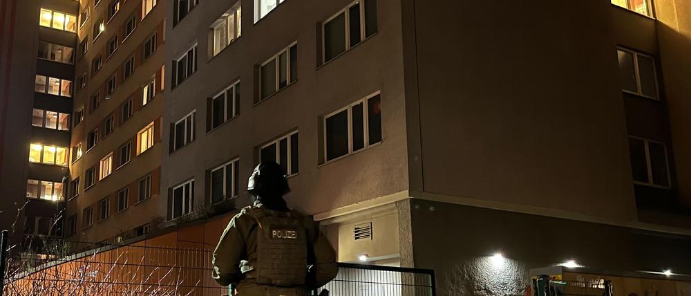 Ein Polizist steht vor einem Hochhaus in Berlin-Friedrichshain. Erneut hat es auf der Suche nach den beiden früheren RAF-Terroristen Garweg und Staub einen großen Polizeieinsatz eines Spezialeinsatzkommandos der Polizei aus Niedersachsen in Berlin-Friedrichshain gegeben. 