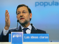 Ein Mann mit einer Maske, die Spaniens Premier Rajoy zeigt, hält sich ein Auge zu und legt den Finger an die Lippen.