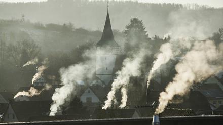 Rauchende Schornsteine über einem Dorf. 