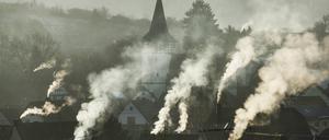 Rauchende Schornsteine über einem Dorf. 