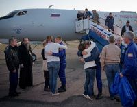 US-Astronaut Nick Hague (Mitte,r) und der russischen Kosmonaut Alexey Ovchinin (Mitte,l) umarmen nach der geglückten Notlandung in Baikonur ihre Angehörigen.