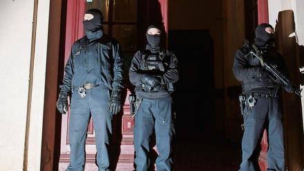 Mitglieder eines Polizei-Sonderkommandos stehen in Berlin vor einem Mehrfamilienhaus. (Symbolbild)