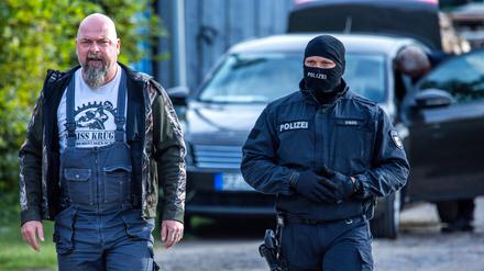  Sven Krüger (l.), bundesweit bekannter Rechtsextremist, wird bei einer Durchsuchungsaktion auf seinem Grundstück in Jamel von einem Polizeibeamten begleitet. 