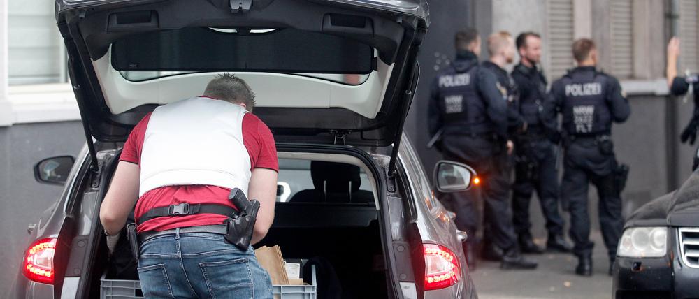 Polizisten stehen vor einem Haus in Duisburg, in dem sie eine Wohnung durchsucht haben. 
