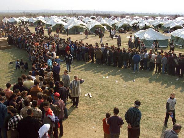 Tausende Kosovar:innen stehen im April 1999 Schlange in einem von der Nato angelegten Lager, um Essen zu bekommen.