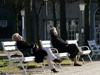 Senioren sitzen in Leichlingen mit Gehstöcken auf einer Parkbank.