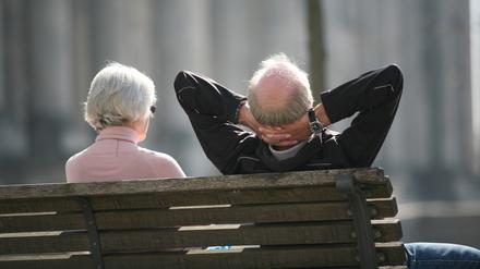 Ein Rentnerpaar sitzt auf einer Bank und sonnt sich. (Symbolbild)